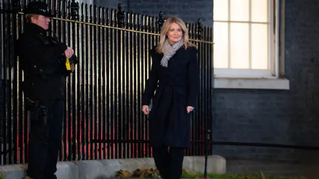 Esther McVey walking past a security guard outside the Downing Street railings