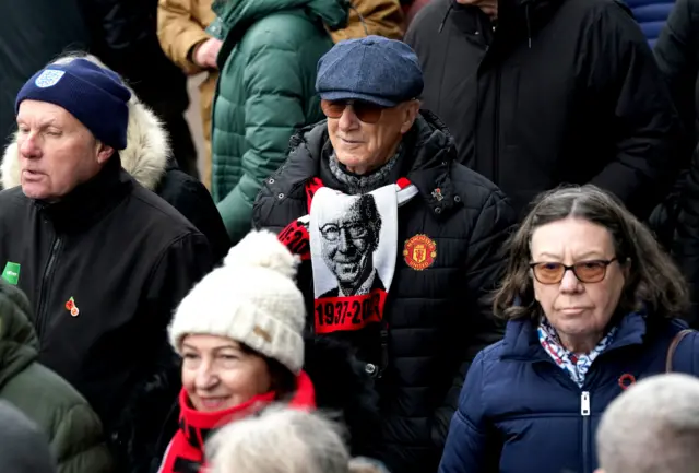 A mourner wearing a Sir Bobby Charlton scarf at Old Trafford