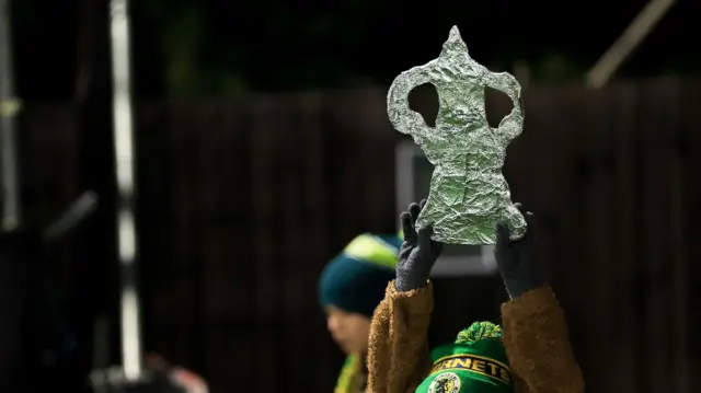 Horsham fan holds up foil cut-out of FA Cup