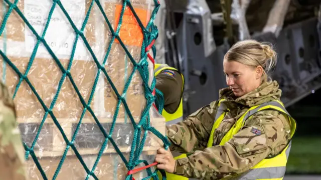 A handout picture provided by the UK Ministry of Defence (MoD) of 99 Squadron Movers loading a Royal Air Force C-17 aircraft with UK aid at Brize Norton, Britain, 25 October 2023.