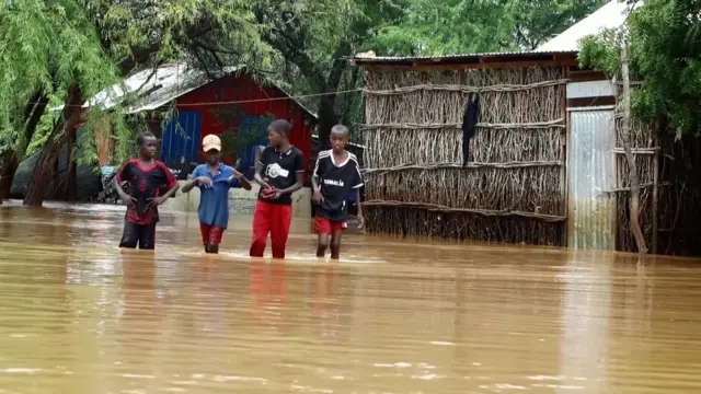 Three boys walking through water in Somalia's Dolow district