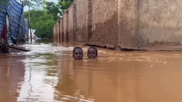 Two boys immersed in deep water, with their heads out