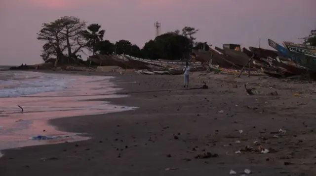 This image grab taken from an AFP video shows a man walking on a beach, in Barra on December 5, 2019