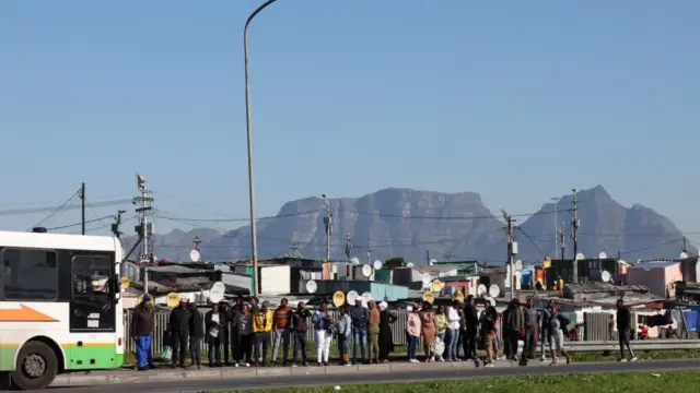 Commuters wait to board a bus outside Nyanga during the ongoing strike by taxi operators over a number of grievances against traffic authorities in Cape Town, South Africa, August 10, 2023