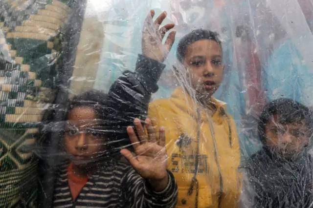 Palestinian children take shelter in a UNRWA school struggle with downpour, strong winds and flooding in Rafah