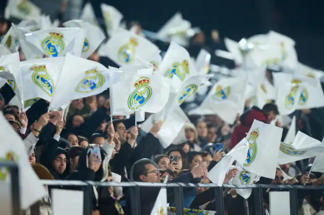 Madrid fans wave flags with the club crest on before kick off.