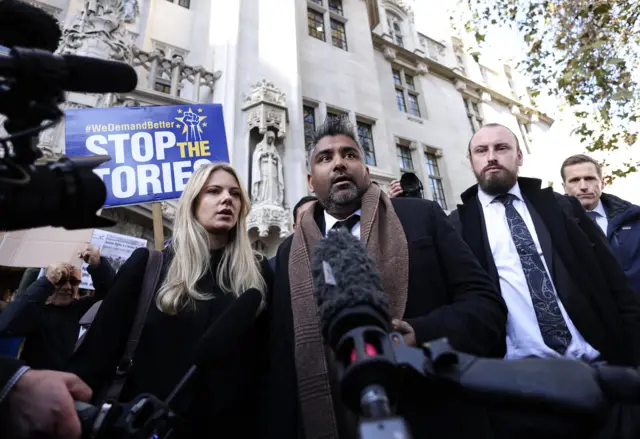 Duncan Lewis Solicitors' director Toufique Hossain (C) speaks to members of the media outside the Supreme Court