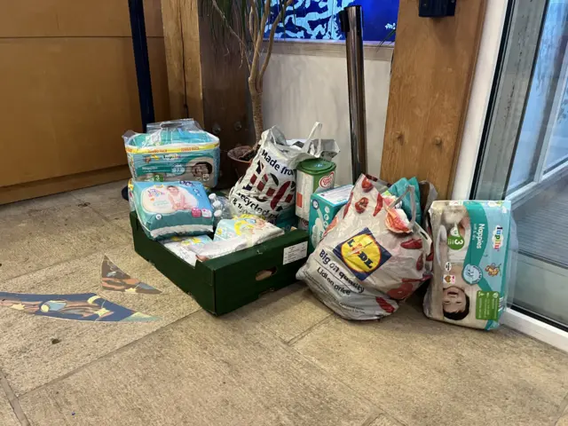 Nappies and shopping bags piled in a corner