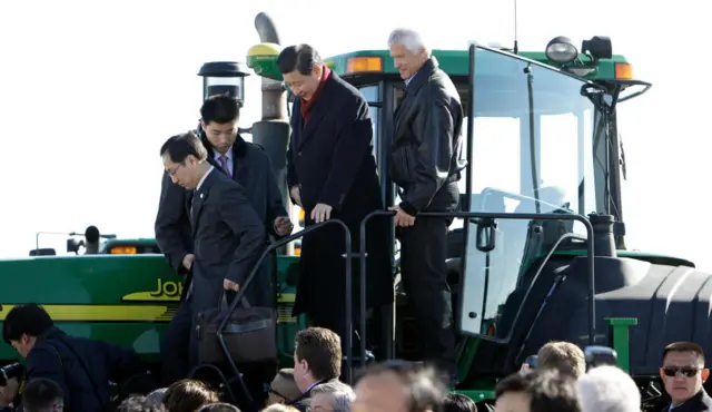 Xi Jinping (centre) climbs out of the cab of the tractor with Rick Kimberley (r) while touring his family farm in 2012