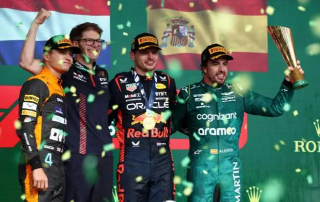 Lando Norris, Max Verstappen and Fernando Alonso celebrate on the Brazil podium