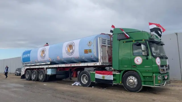 A stationary fuel truck adorned with Palestinian flags