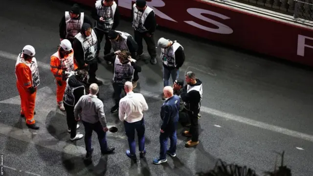 Stewards check the drain covers at the Las Vegas Strip circuit