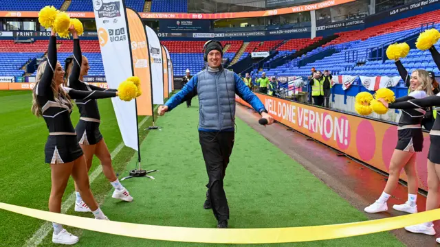 Vernon Kay crosses the finish line with cheerleaders