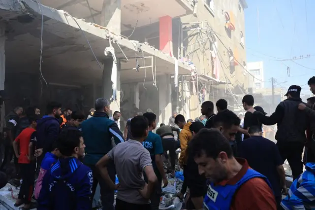 Palestinians inspect damaged buildings and rubble