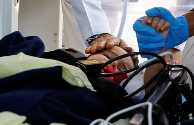 Medics receive an injured boy as Palestinian children and families arrived in Abu Dhabi, 18 November 2023