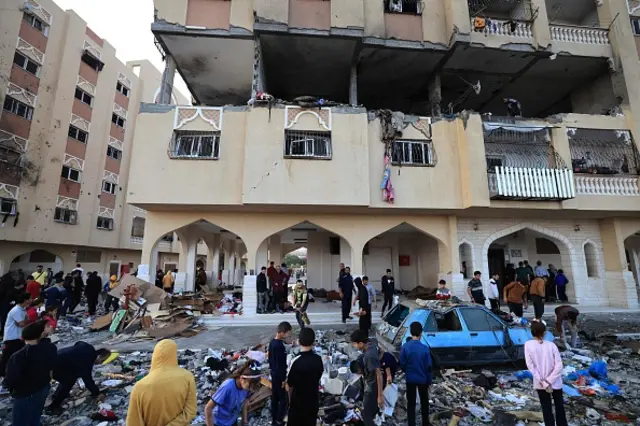 Palestinians inspect the damage to a building after an Israeli strike on Hamad City in Khan Yunis on November 18, 2023.