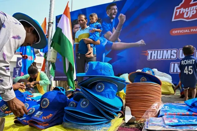 A street vendor sells Indian team caps and jerseys outside the stadium