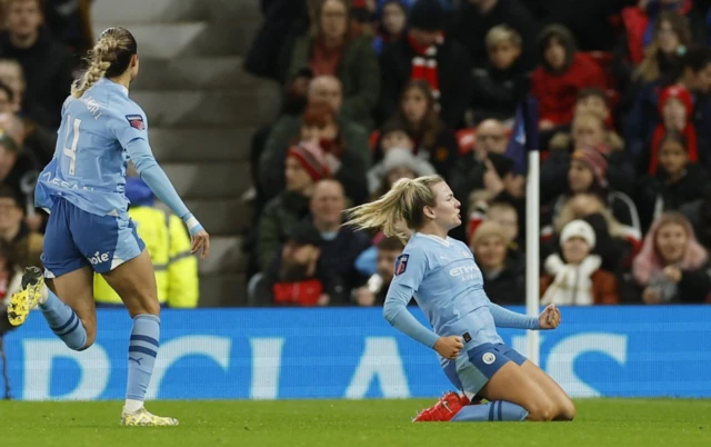 Lauren Hemp celebrates sliding on her knees after scoring