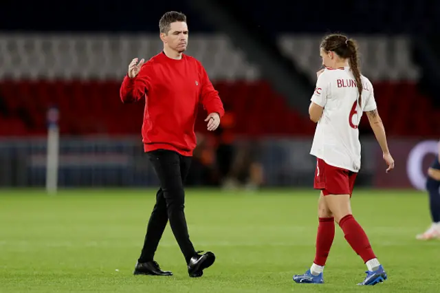 Manager Marc Skinner of Manchester United Women talks to Hannah Blundell