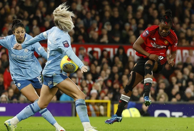 Leila Ouahabi  shoots with the ball striking Alex Greenwood's arm