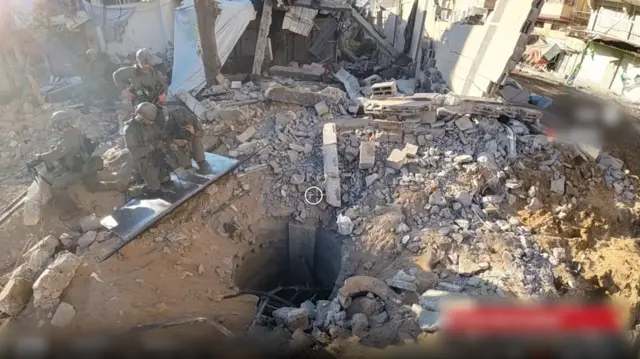 Five Israeli troops crouch near a tunnel