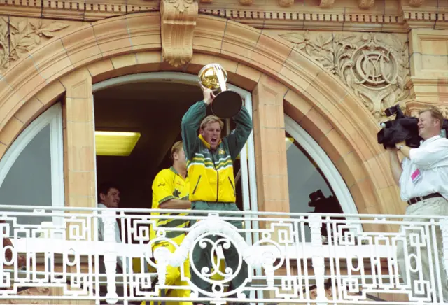 Australia leg spinner Shane Warne celebrates with the trophy on the players balcony after the 1999 ICC Cricket World Cup Final between Australia and Pakistan at Lords on June 20th, 1999 in London, United Kingdom.