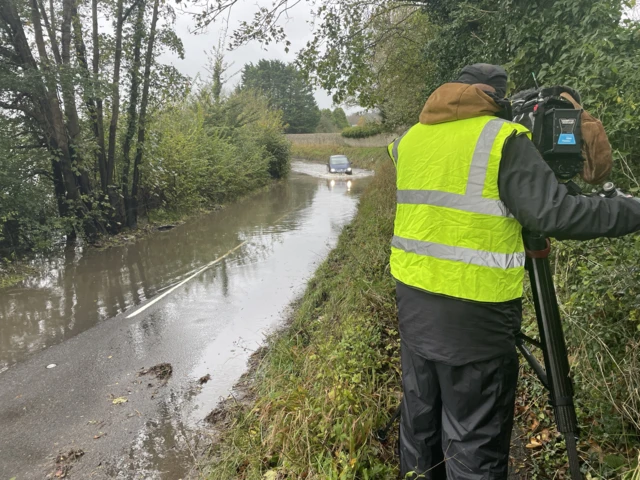 Camera man filming flooded road