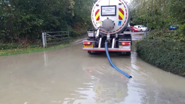 A vehicle being used to pump water off a road.