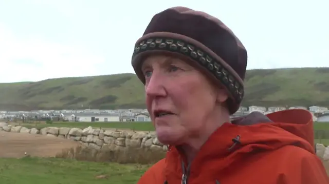 Julie Lewins standing with caravan park in the background