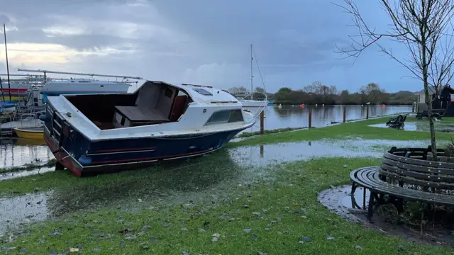 A boat washed up on grass in Christchurch, Dorset