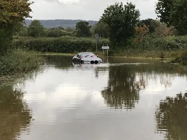 A car floating in the water outside the village of Broadway in Somerset