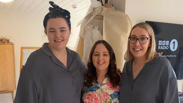 Bride Leah Baldoch (centre) with her bridesmaids Sophie (right) and Becca (left). They are in their pyjamas as they get ready for Leah's wedding in Bedford as they listen to BBC Radio 1 on the TV in their hotel room.