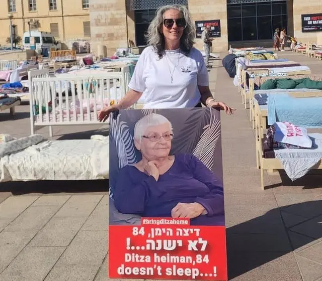 Neta Heiman Mina with hostage poster of mother