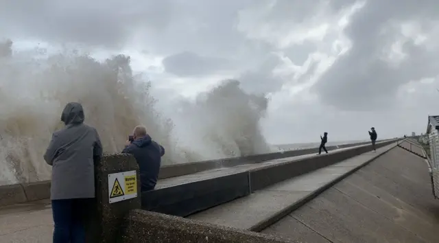 People gather to watch the weather at Lowestoft seafront