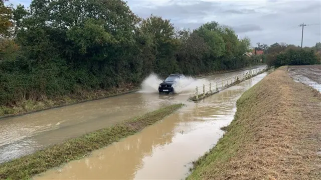 Winfarthing near Diss, car drives through flood water