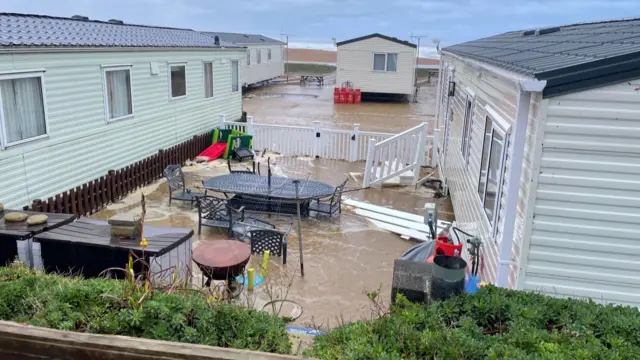 Holiday homes at Freshwater Beach Holiday Park with water surrounding them