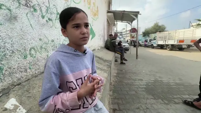 Rafif sits on a concrete barrier