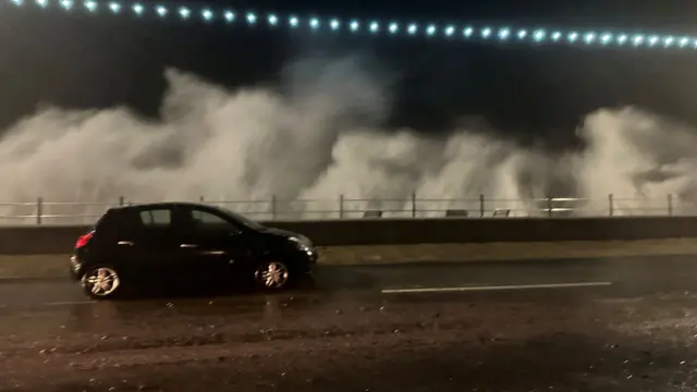 A vehicle passes by as the breeze of high waves caused by storm Ciaran is seen in the background, in Penzance, Cornwall, Britain, November 1, 2023 in this picture obtained from social media. David Haigh/via REUTERS THIS IMAGE HAS BEEN SUPPLIED BY A THIRD PARTY. MANDATORY CREDIT. NO RESALES. NO ARCHIVES