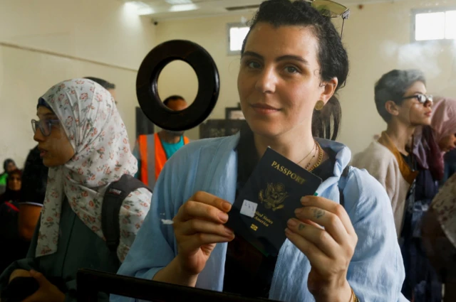 Suzan Besaiso, a Palestinian holds a US passport as she waits for permission to leave Gaza