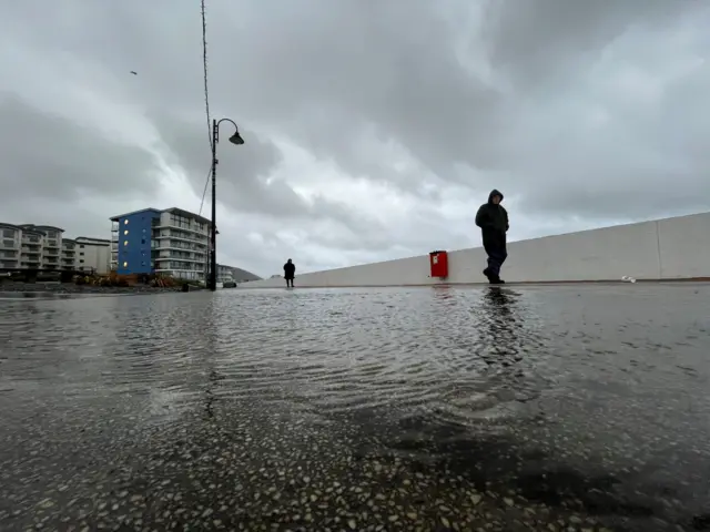 People braving the rain in Westward Ho!