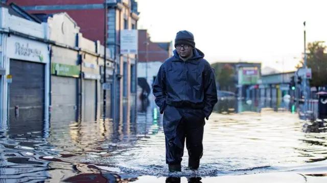 Man walks through flood water on Market Street in Downpatrick, Northern Ireland. Some rivers in Northern Ireland reached record high levels following several days of heavy rain. Picture date: Thursday November 2, 2023.