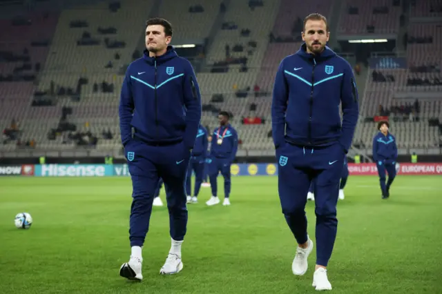 Maguire and Kane walk ahead of the players with hands in pockets.