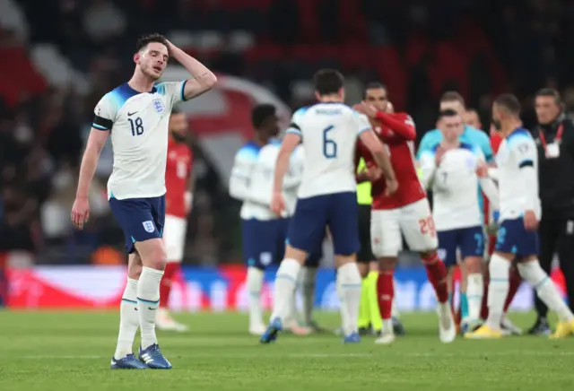 Rice wipes his head and sighs with tiredness as players shake hands behind him on the Wembley pitch.