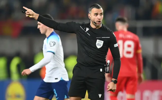 The ref shouts instructions and points his hands.