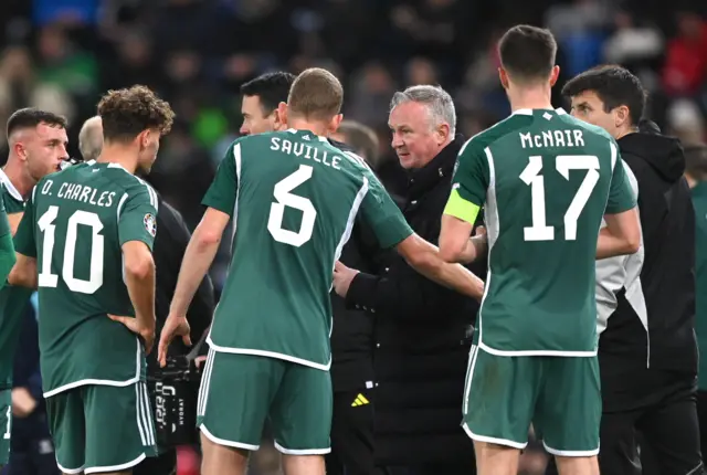 Michael O'Neill talks with his players after the goal.