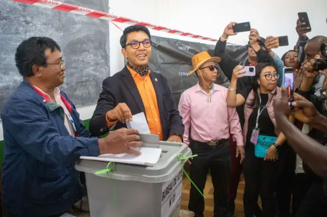 Madagascar President Andry Rajoelina (2nd L) casts his ballot at a polling station in Ambatobe, Antananarivo, on November 16, 2023, during the first round of the Madagascar presidential election. Polls opened on November 16, 2023 in Madagascar's presidential election, which is being boycotted by most opposition candidates over concerns about the vote's integrity.