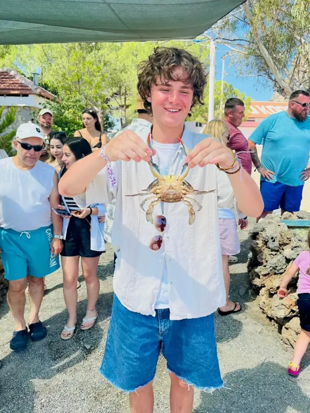 A family photo of Harvey Owen, holding a crab