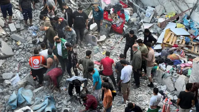 Palestinians search for casualties at the site of Israeli strikes on houses in Jabalia refugee camp,