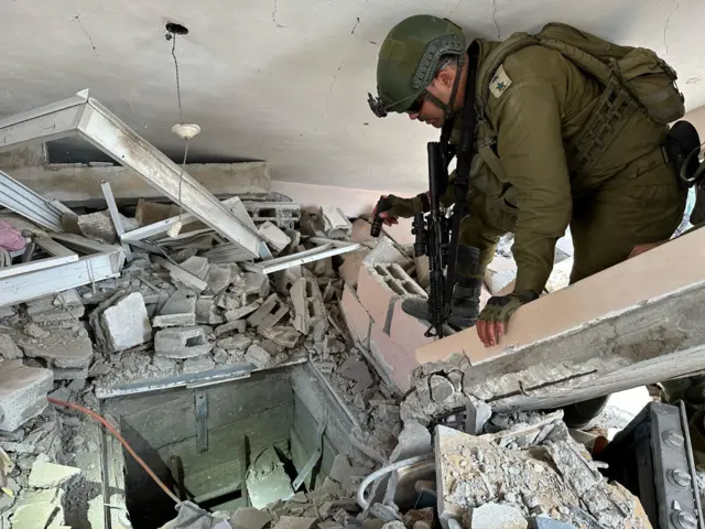 An IDF solider peers into what appears to be a tunnel shaft in Gaza