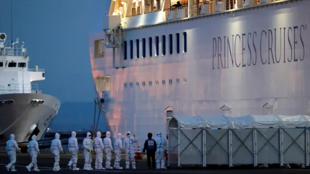 Officers in protective gear enter the cruise ship Diamond Princess